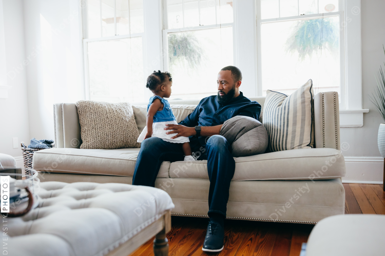 Father with daughter sitting on couch
