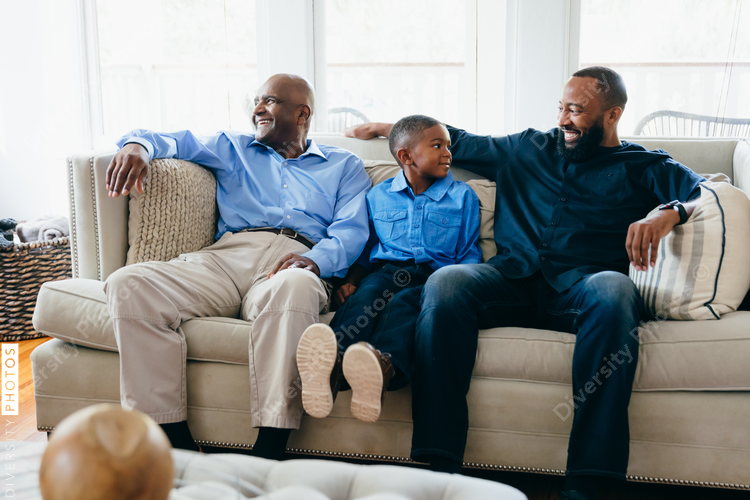 Grandfather, son, and grandson sitting together at home