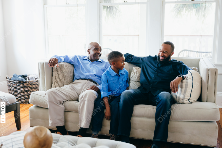 Grandfather, son, and grandson sitting together at home