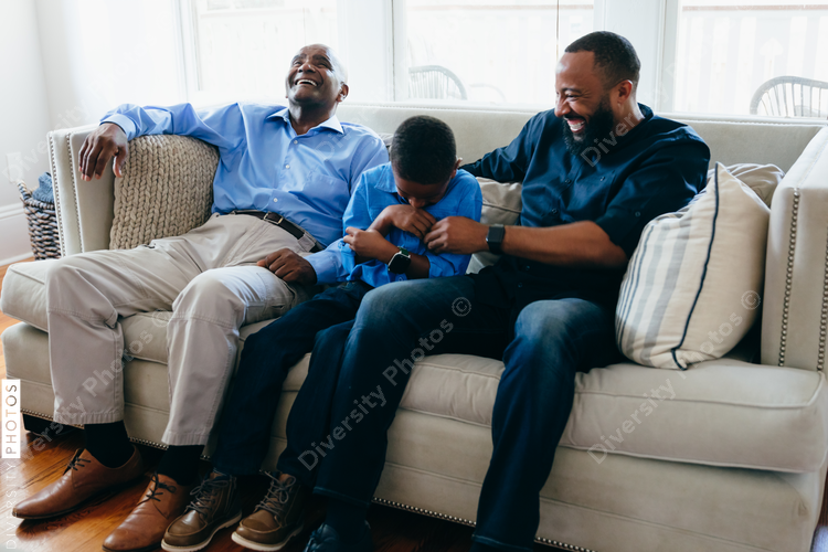 Grandfather, son, and grandson laughing together