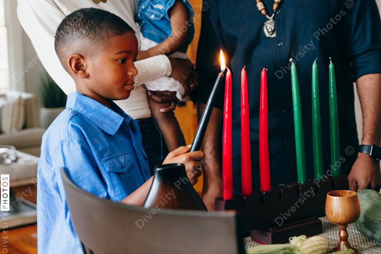 Boy lights candle to celebrate Kwanzaa