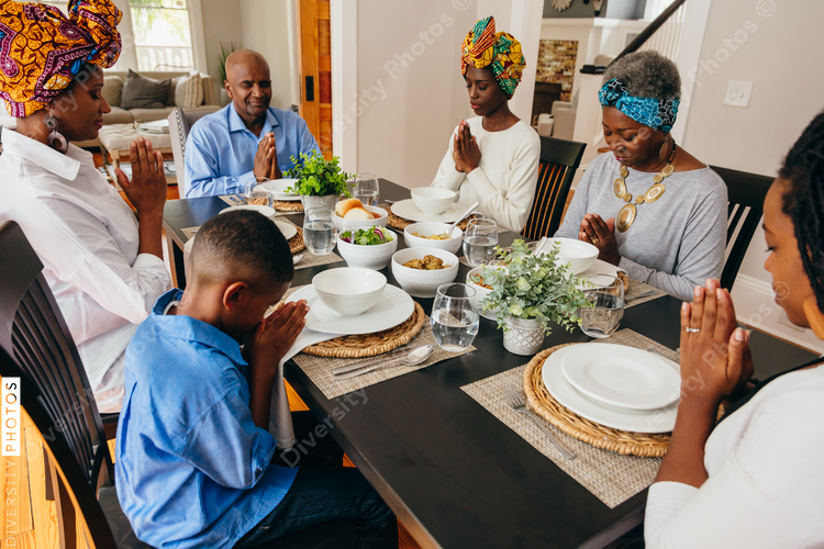 Family prays together at dinner table