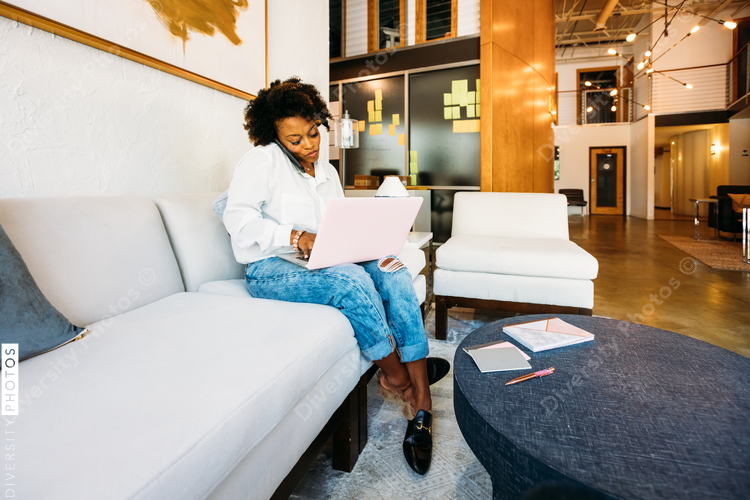 Woman talking on mobile phone and working with laptop
