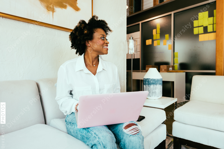 Woman working on laptop and looking aside