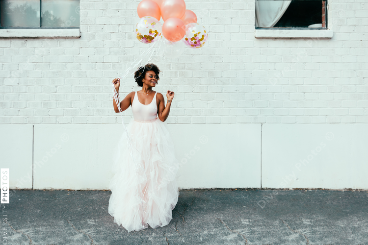Smiling woman in pink maxi tulle skirt with balloons