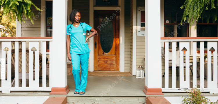 Healthcare professional leaning against pillar in front of house