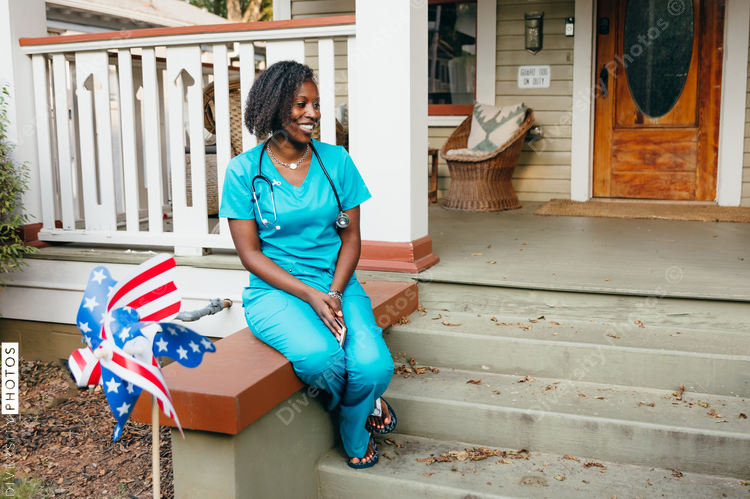 Healthcare professional  sitting in front of house and smiling