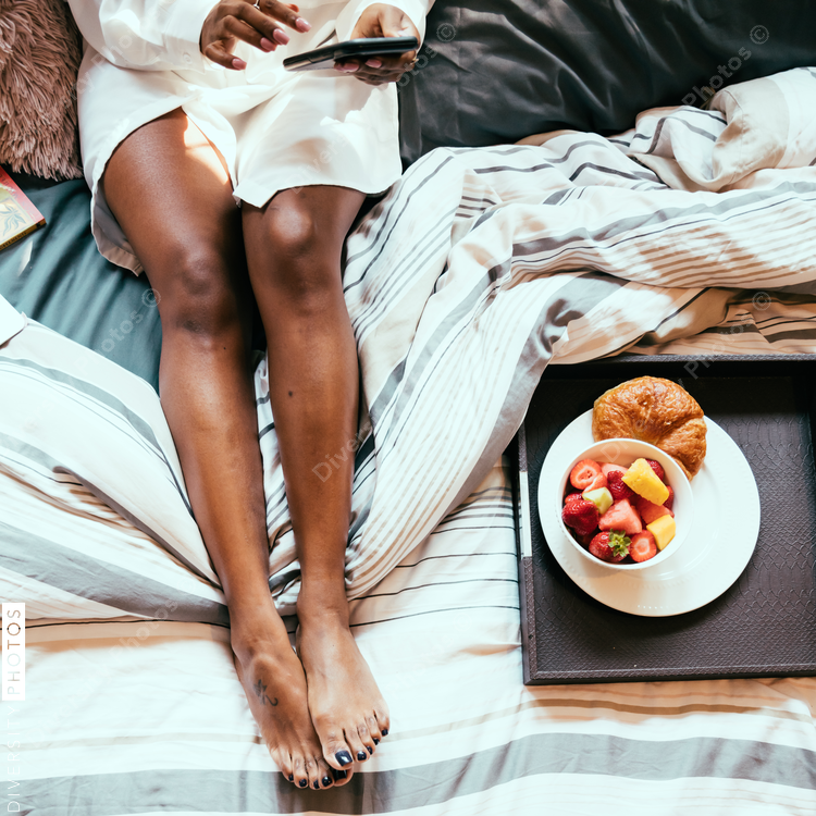 Directly above view of woman on bed looking at her mobile phone