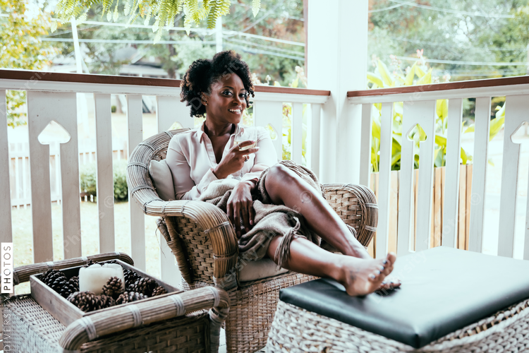 Woman relaxing on patio with wine glass in hand
