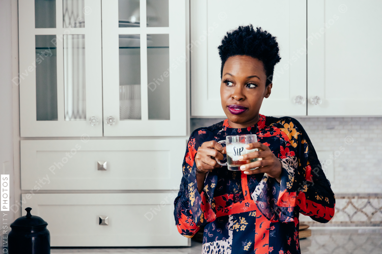 Woman holding wine glass in kitchen