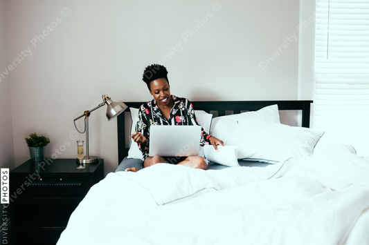 Woman working on laptop in her bedroom