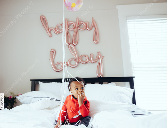 Baby playing with birthday balloons