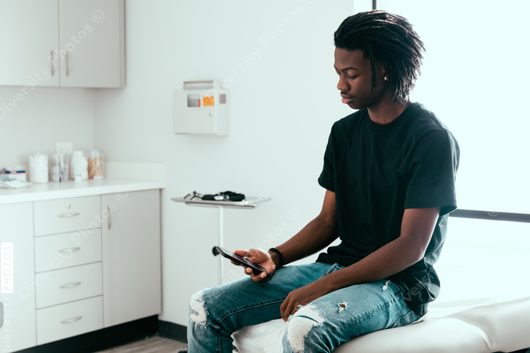 Teenage boy waits to be seen by doctor