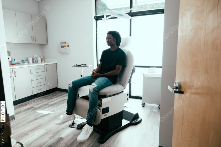 Teenage boy waits to be seen by doctor