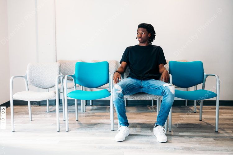 Gen Z boy sitting in doctors wait area