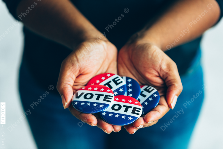 Black hands holding vote buttons