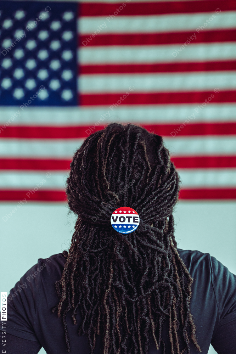 Black citizen looking at American Flag with Vote button