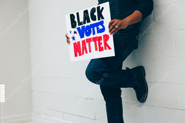 Man holding Black Votes Matter protest sign