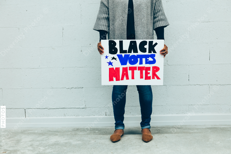 Woman holding Black Votes Matter protest sign