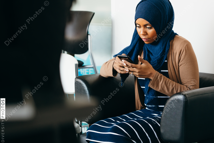 Muslim Woman Sitting and Looking at Phone