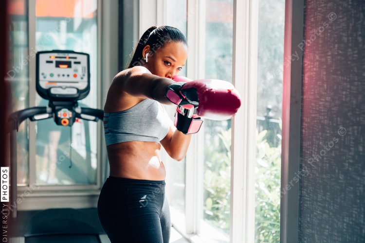 Young woman wearing boxing gloves