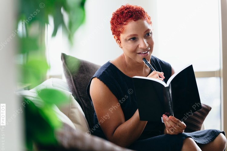Black woman reading a book at home during pandemic