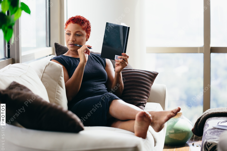 Black woman reading a book at home during pandemic
