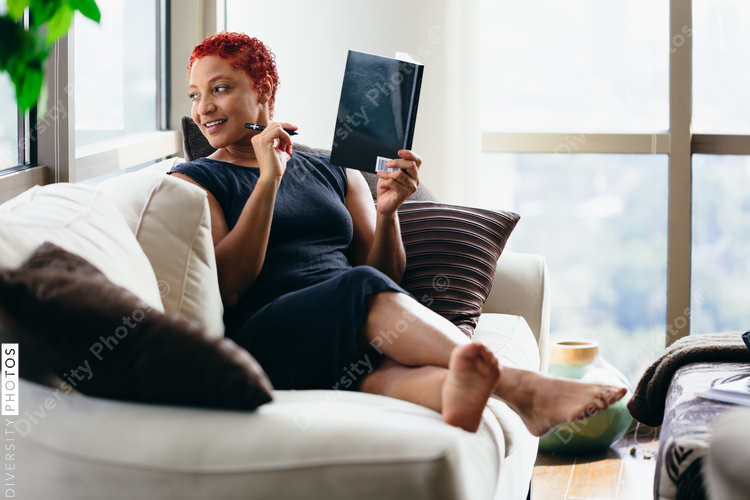 Black woman reading a book at home during pandemic