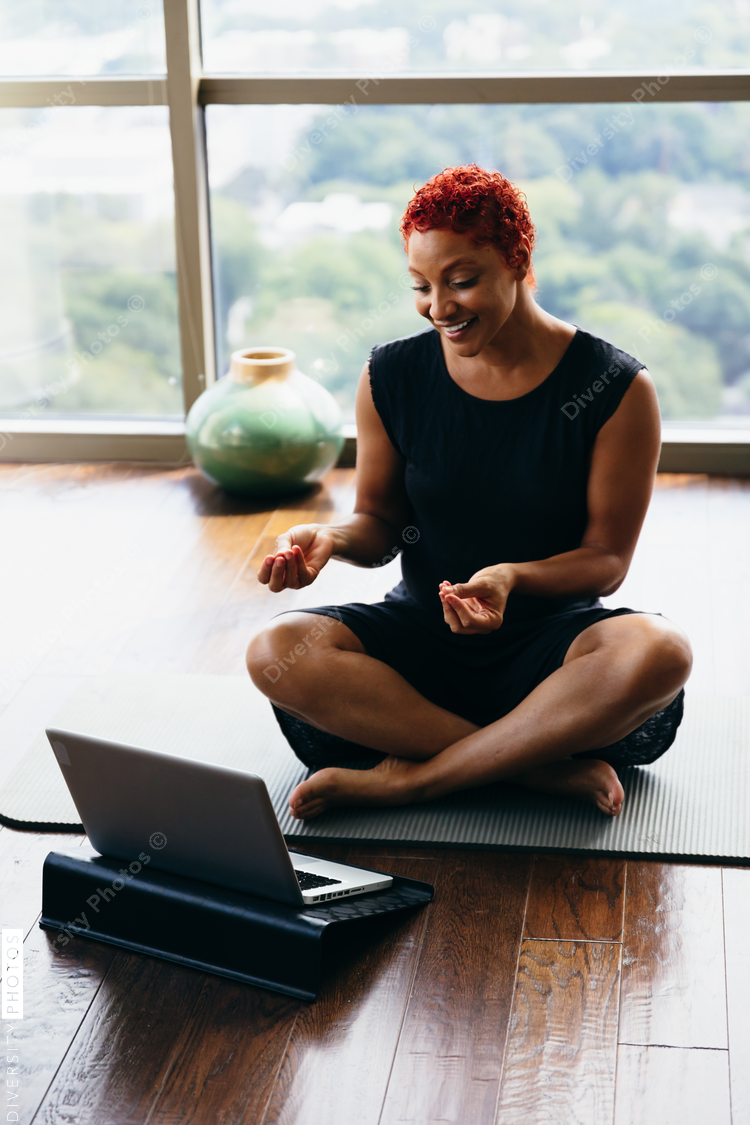 Woman doing virtual group meditation workout at home