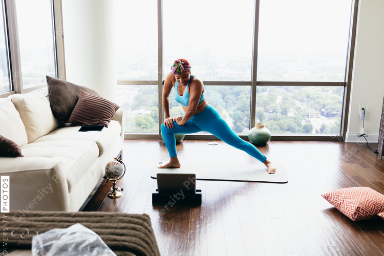 Black woman doing virtual yoga session at home