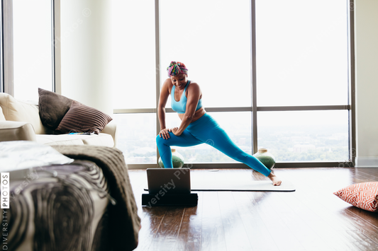 Black woman doing virtual yoga session at home
