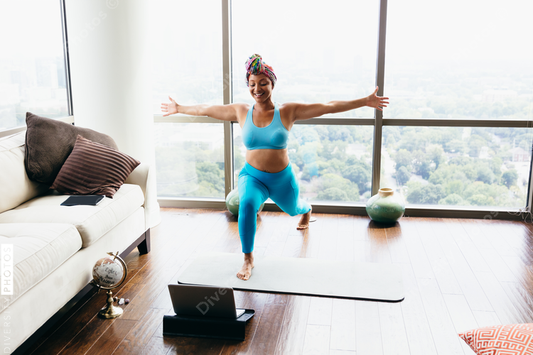 Black woman doing virtual yoga session at home