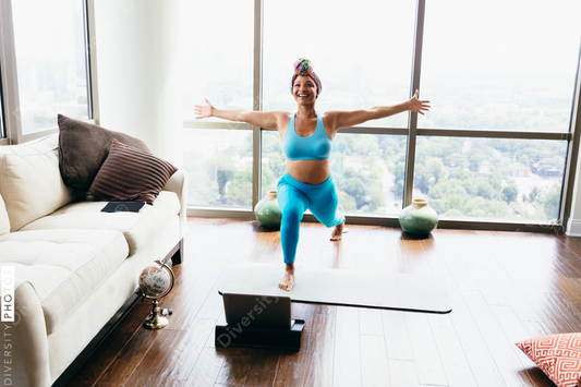 Black woman doing virtual yoga session at home