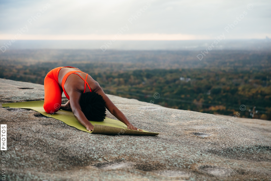 Black woman doing yoga at park