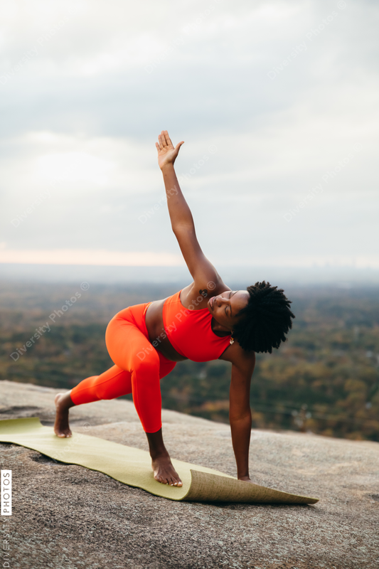 Black woman doing yoga at park