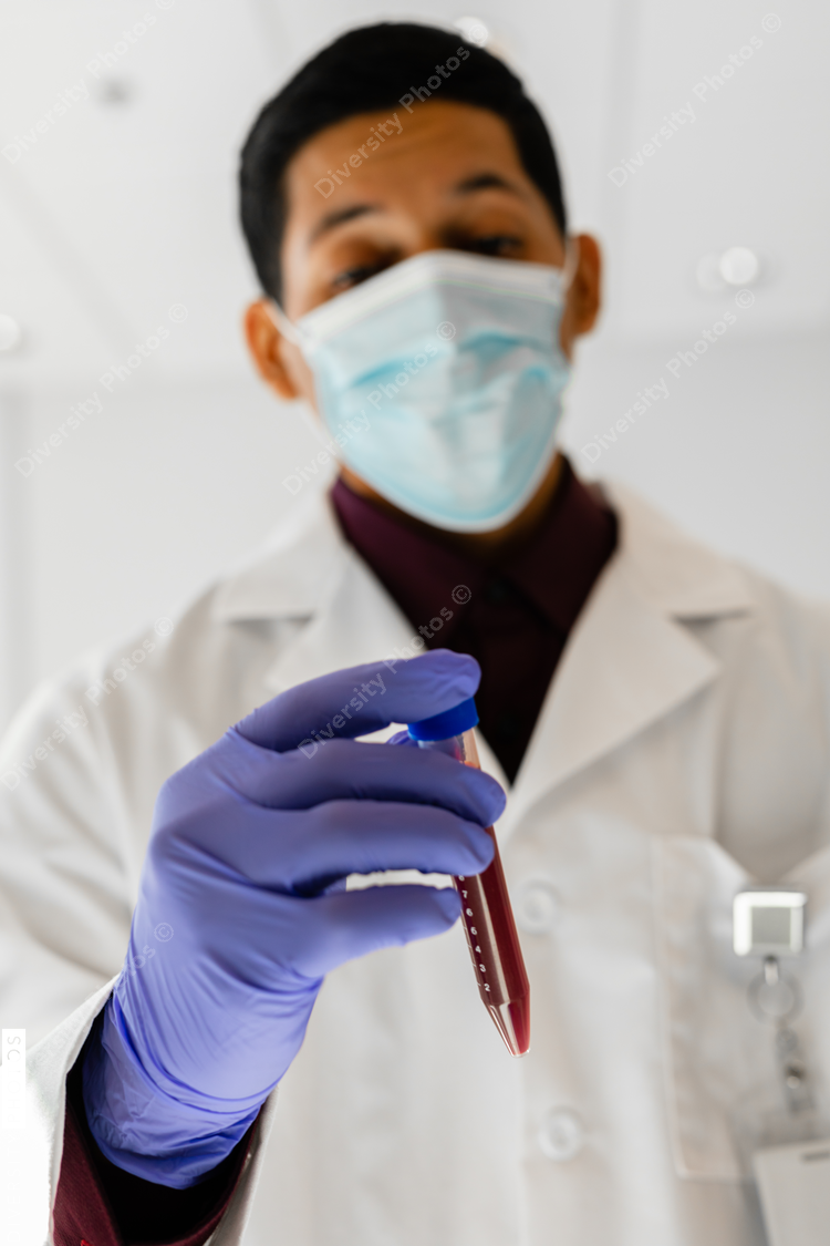 Hispanic medical professional in a mask with blood sample