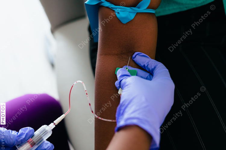 Black nurse collects blood sample from female patient at doctors office