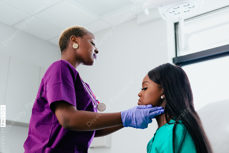 Nurse checking lymph node on black female patient
