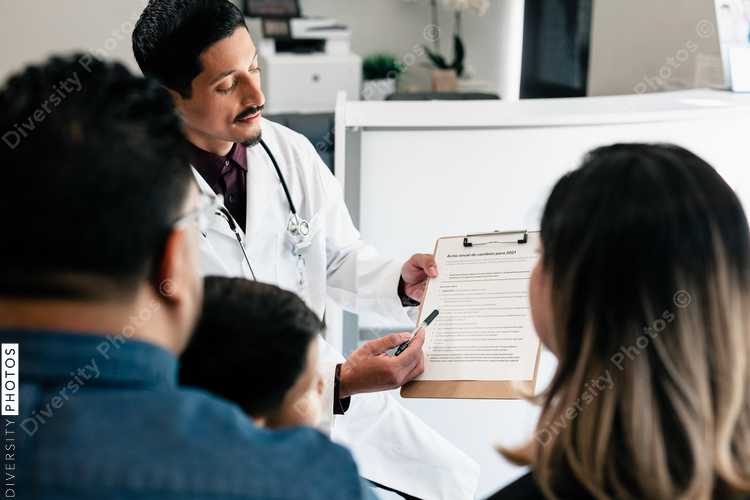 Hispanic doctor reviewing translated documents with diverse patients