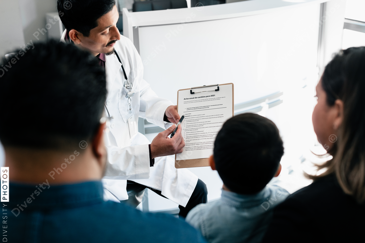 Hispanic doctor reviewing translated documents with diverse patients