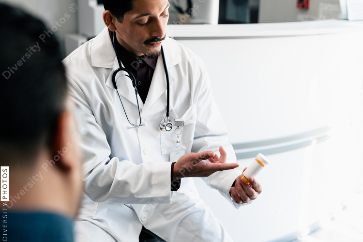 Hispanic doctor discusses prescription pills with family patients