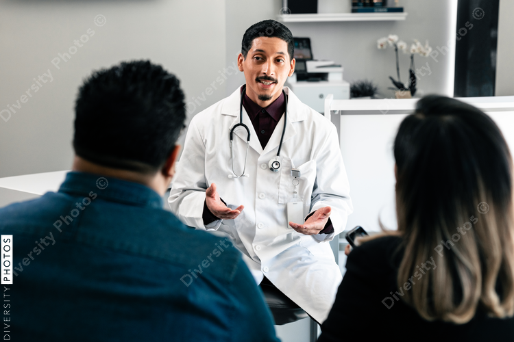 Hispanic family doctor consulting with patients in doctors office