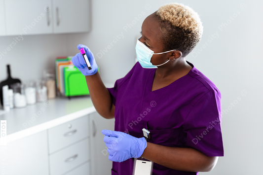 Black female nurse reading blood sample label at medical office