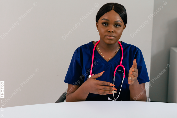 Black female triage nurse having a conversation with client - video chat screen insert