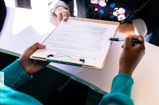 Black nurse reviewing medical forms with Latino family at doctor office