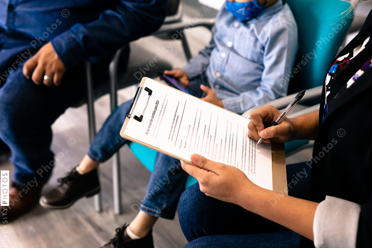 Hispanic family completing Spanish translated medical forms in doctor office