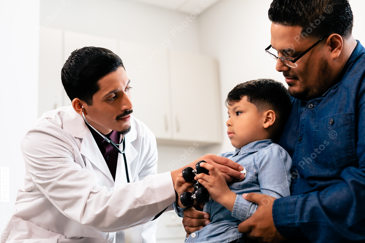 Young hispanic toddler with father and doctor for a physical exam and health check up