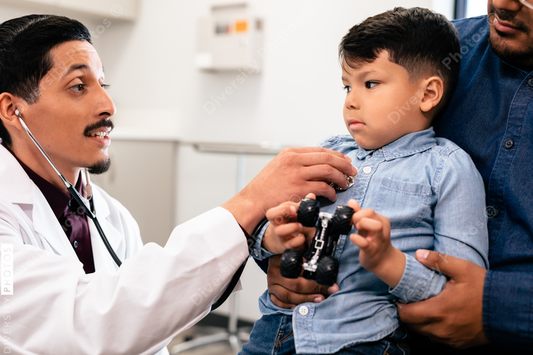 Young hispanic toddler with father and doctor for a physical exam and health check up