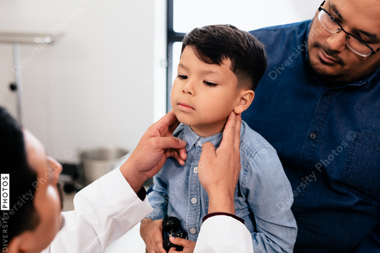 Young latino toddler with father and doctor for a physical exam and wellness visit