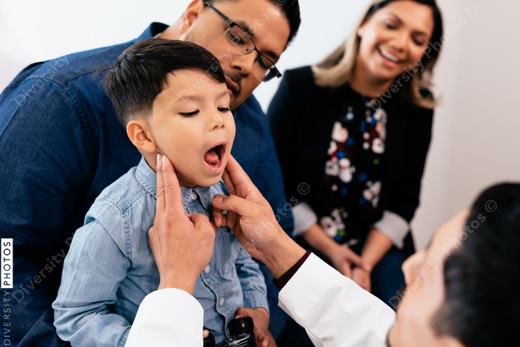 Young latino toddler with father and doctor for a physical exam and wellness visit